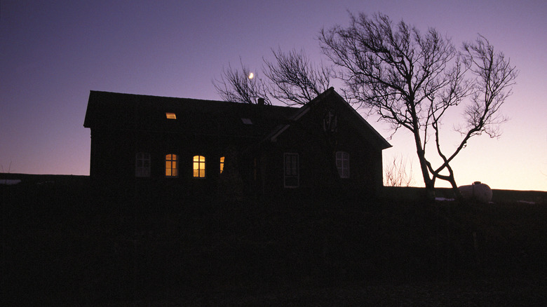 A house with only a few lights on at night