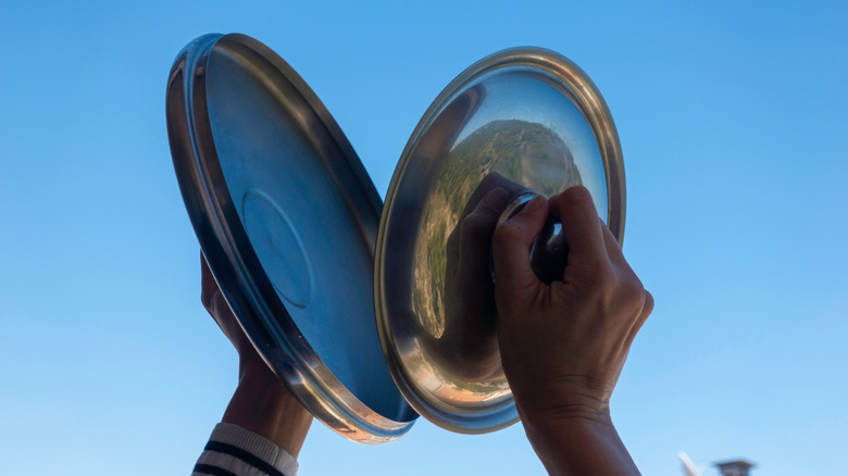 A person banging two pots together