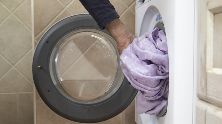 A person removing sheets from the dryer