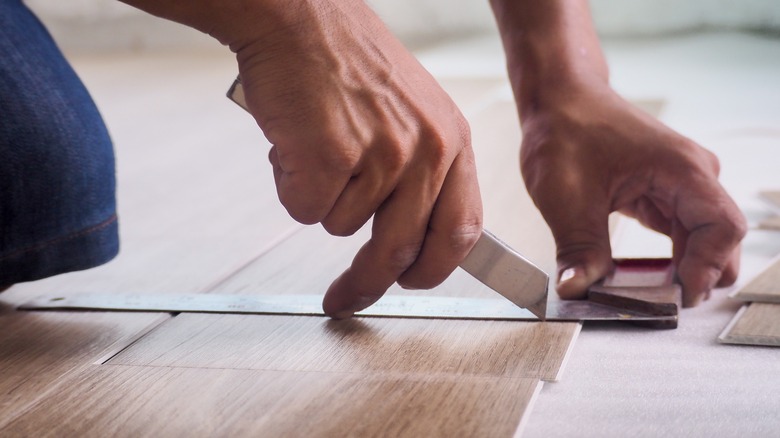 Person cutting luxury vinyl