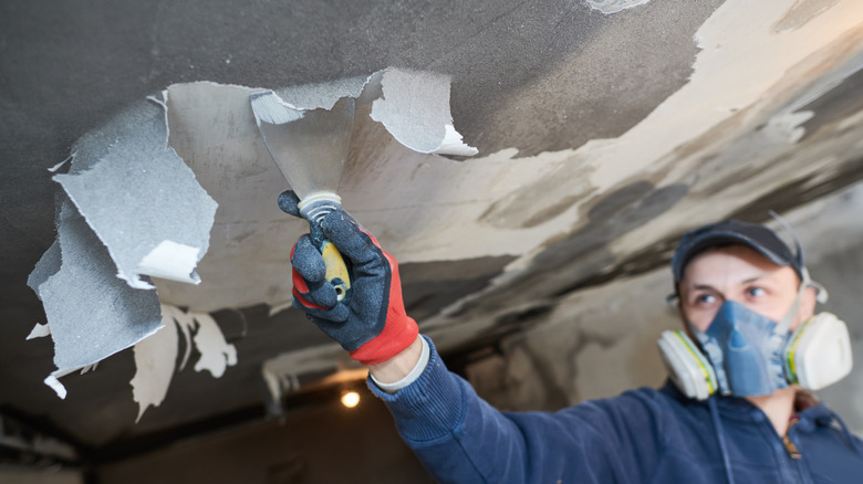 A professional using a tool to remove fire damaged paint