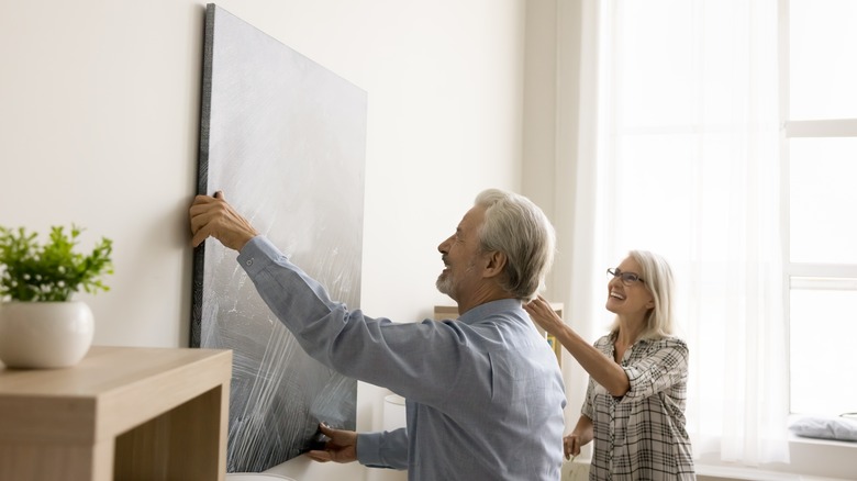 Couple hanging large art piece