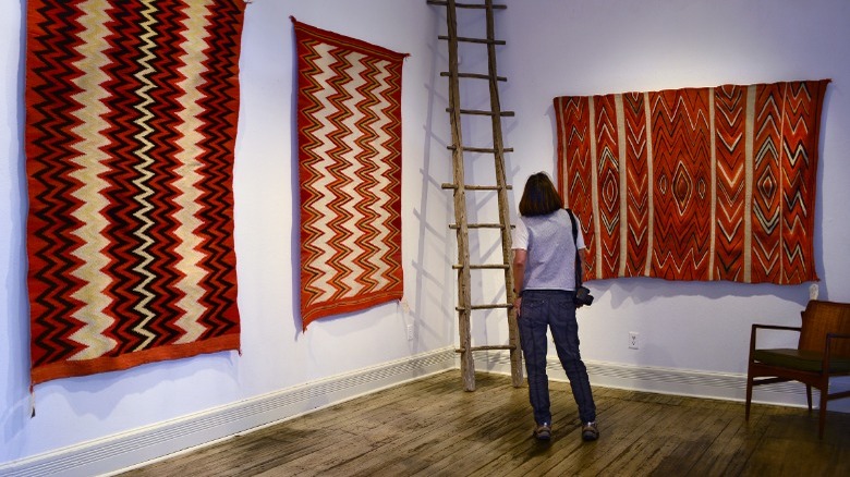 Woman admiring Navajo rugs 