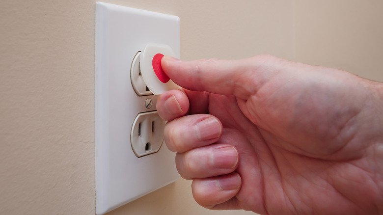 man covering electric outlet