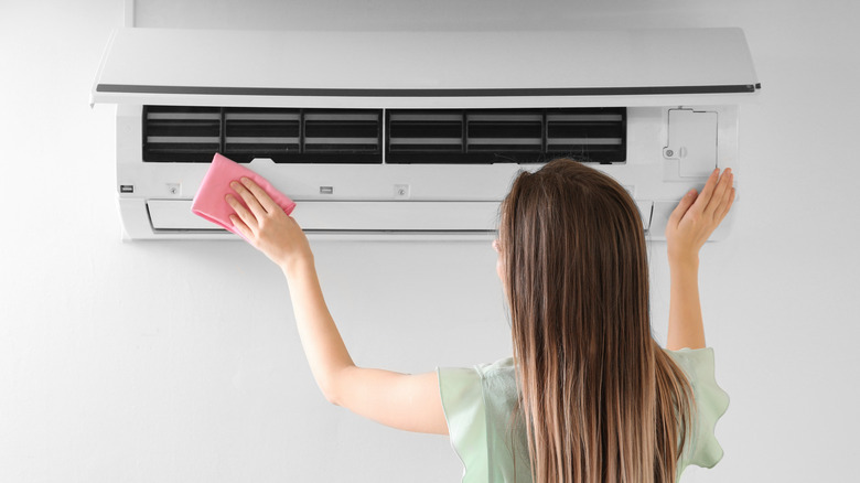 Woman opening air conditioner 