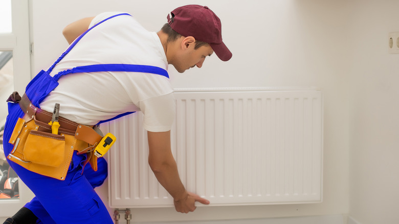 Man repairing radiator heater