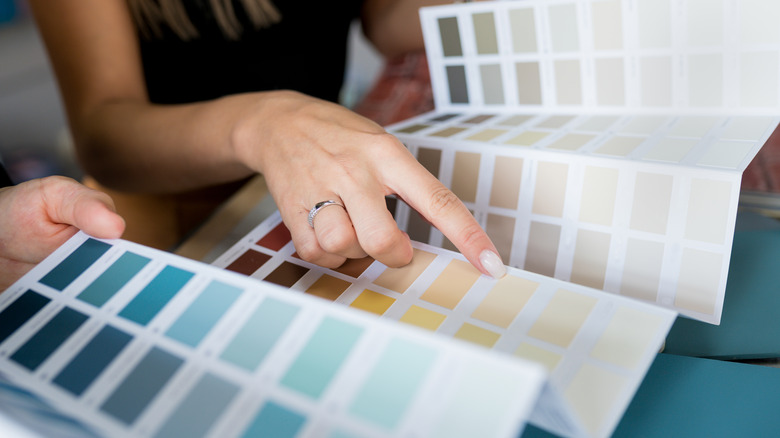 A woman pointing at different paint shades