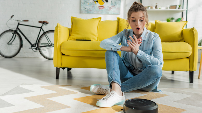 Woman looking at robotic vacuum