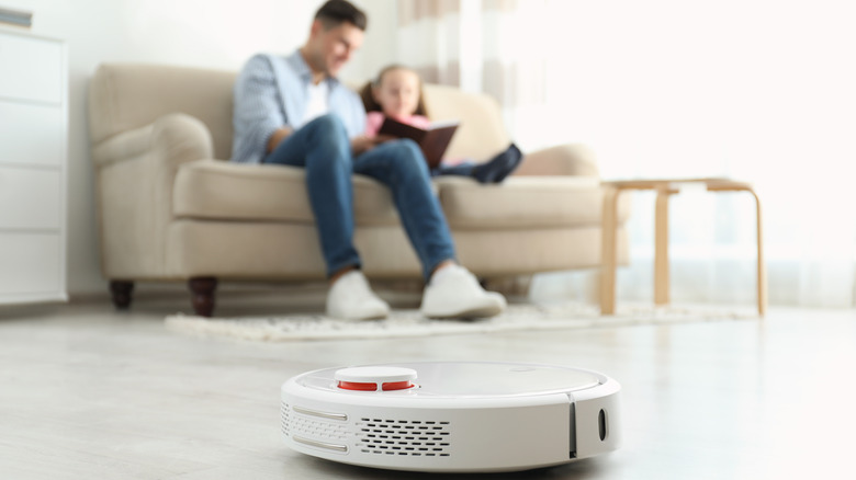 Family relaxing while robotic vacuum runs