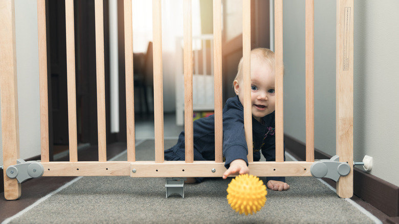 child throwing ball through gate