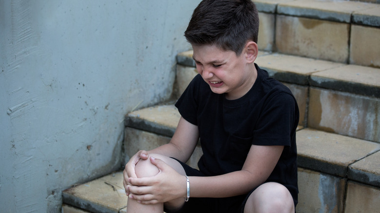 injured boy sitting on stairs