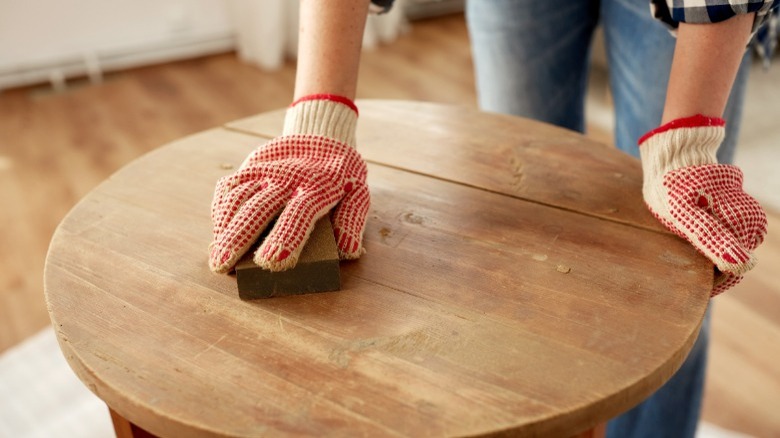 Hand sanding wood table 