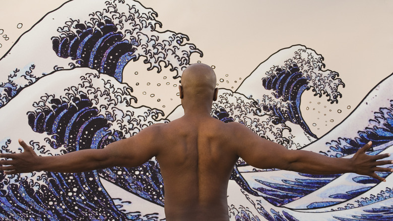 A man standing in front of a mural 