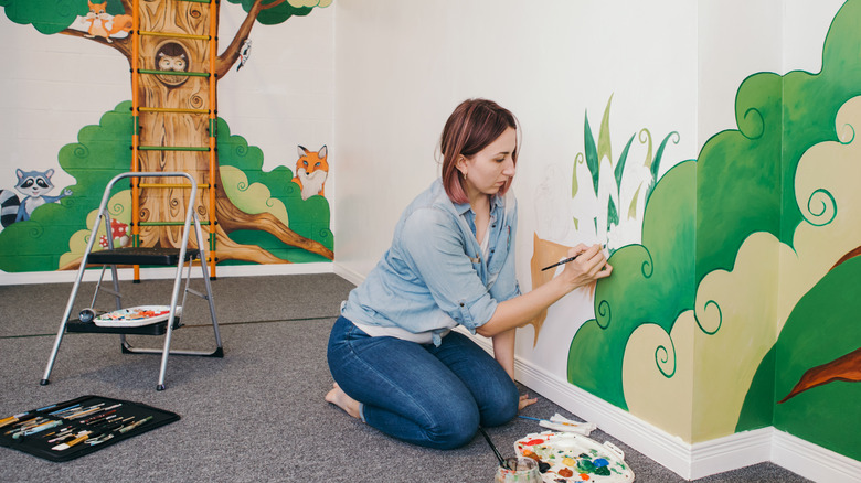 A lady painting a mural 