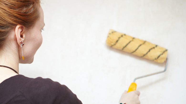 A lady priming a wall 