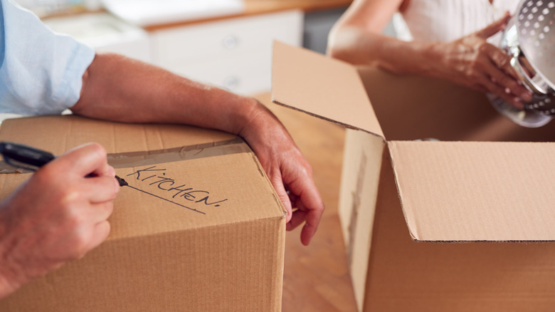 couple packing items in boxes