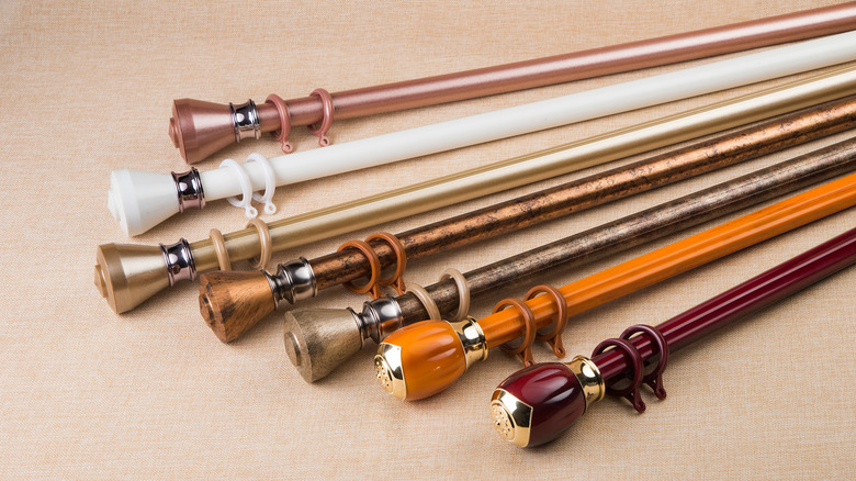 Seven curtain rods with varying colors including white, orange, and dark red