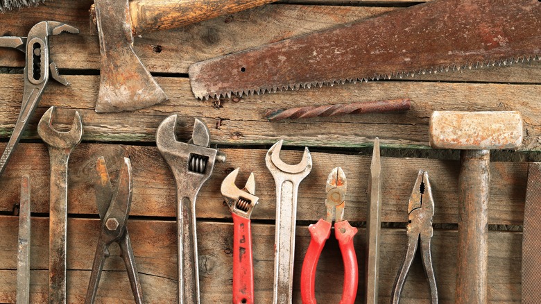 A range of rusty tools on a wooden table