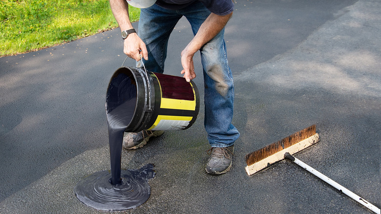 Man pouring driveway sealant