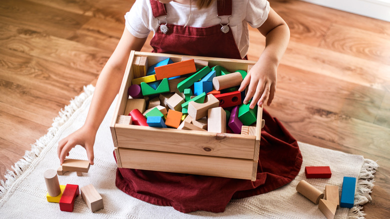 child cleaning toy blocks