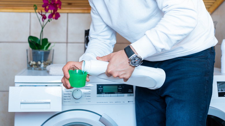 man pouring less detergent