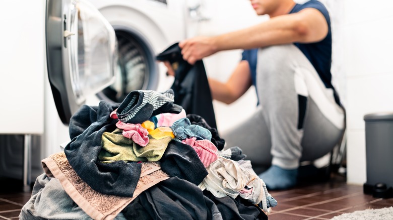 man sorting laundry pile