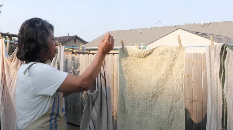 woman drying towels on clothesline