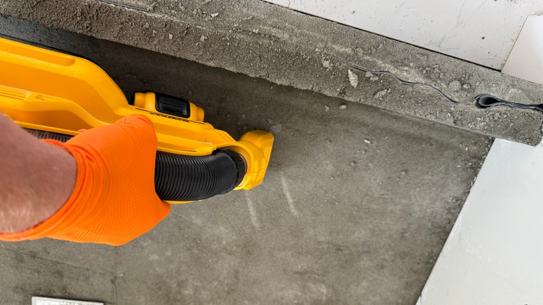 Person preparing a shower tray for waterproofing