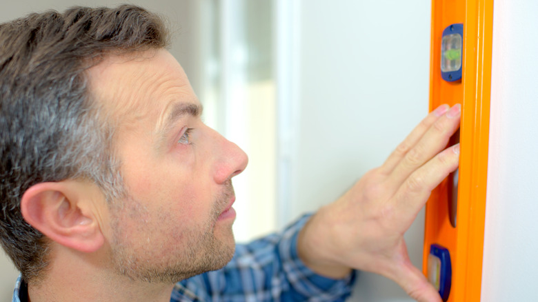 Person using a spirit level on a wall