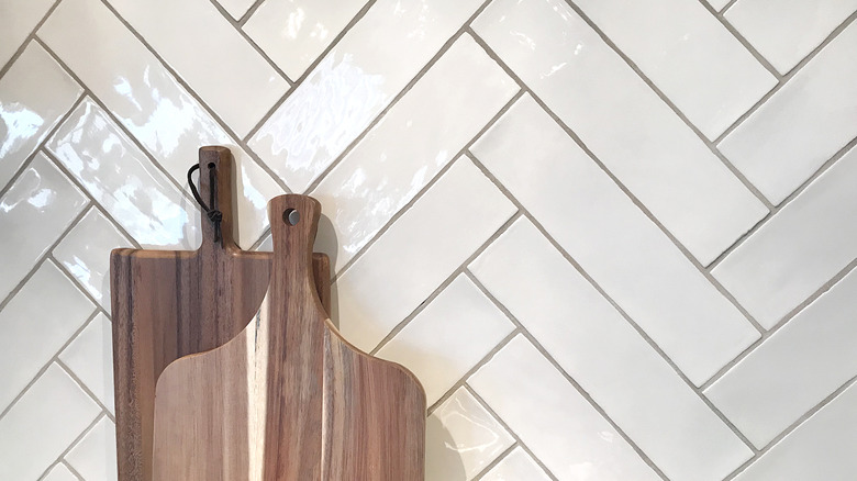 Herringbone tile backsplash with wooden cutting boards