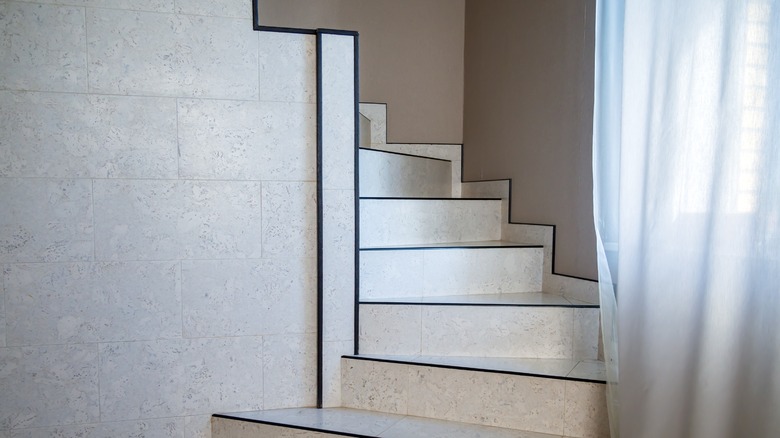 Pale tiled stairway with black trim