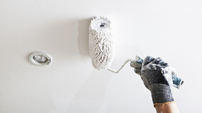 gloved hand painting ceiling flat white