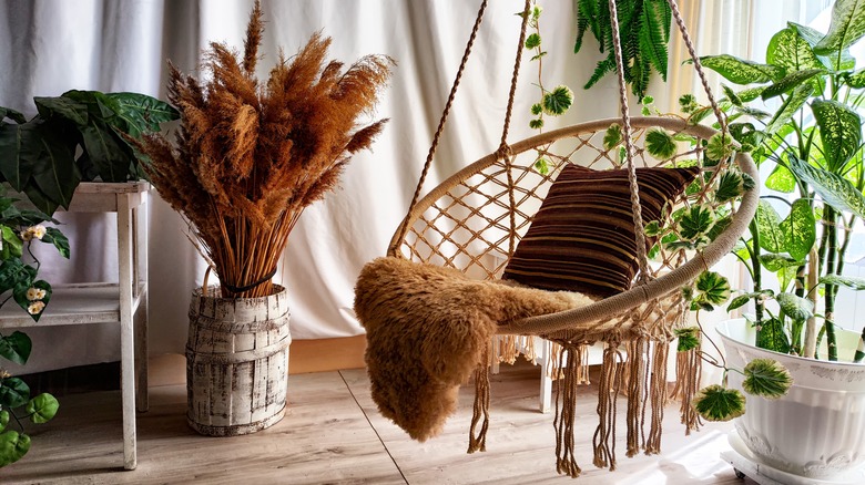 Macrame swing chair surrounded by plants