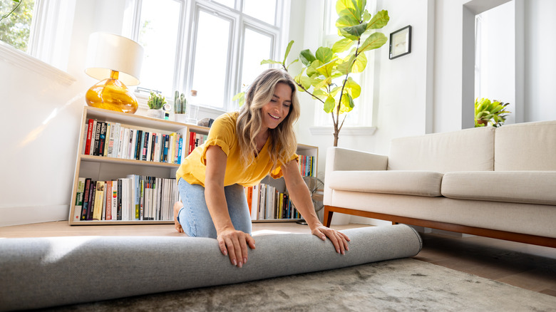 Woman unrolling area rug