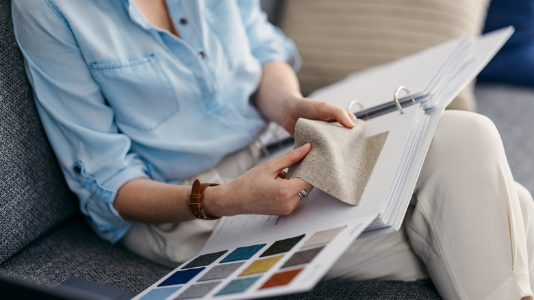 Someone looking through a catalog of fabrics.