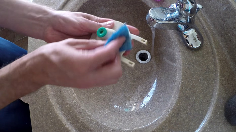 Person cleaning dirty toilet flapper