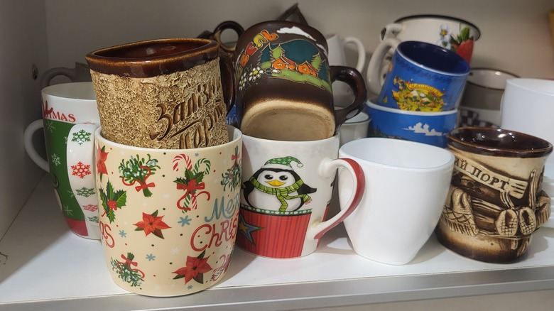 Assorted mugs in cabinet
