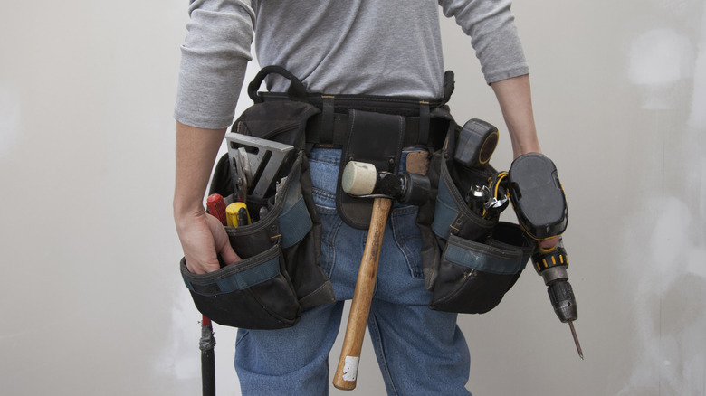 Tradesman's tool belt loaded with various tools