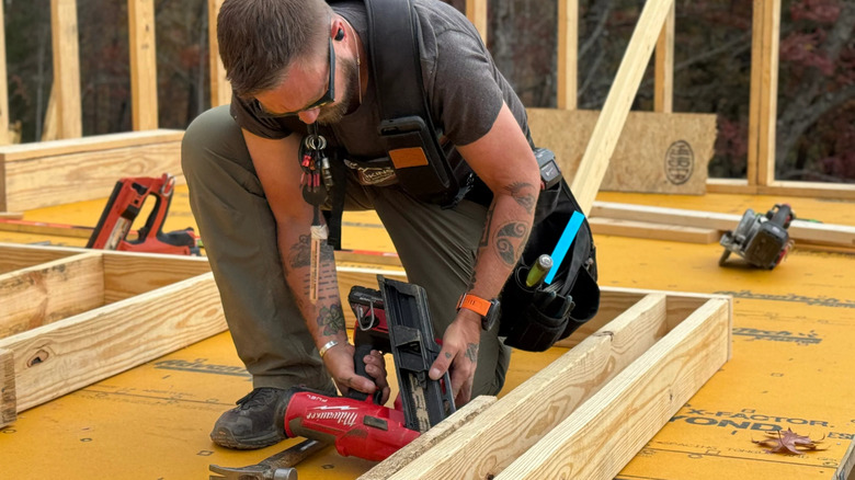 Man with framing nailer and Perkins Brothers tool belt