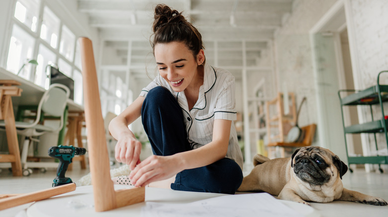 Woman assembles furniture with tool