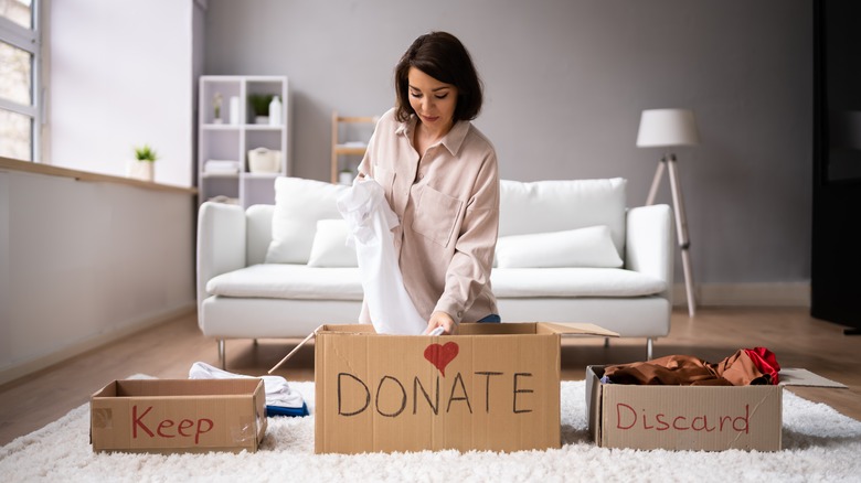 woman organizing clothes to donate