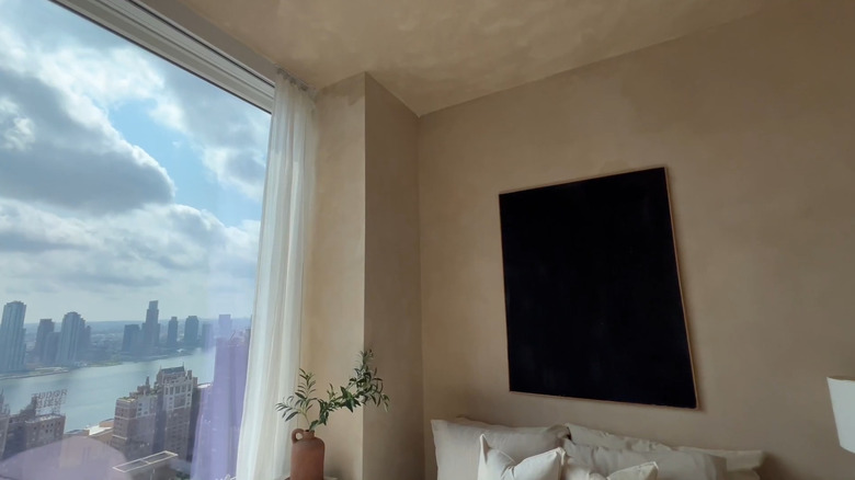 Beige lime wash ceiling and walls in a high rise apartment bedroom with a beautiful view