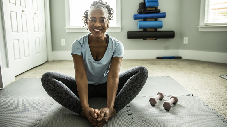 A woman stretches on foam mats.