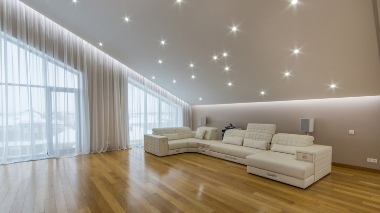 An attic living room has laminate floors and sparkling lights.