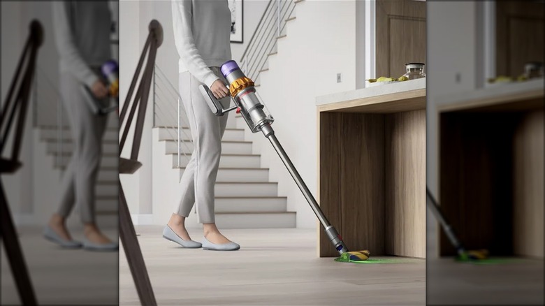 woman vacuuming wood floor in home