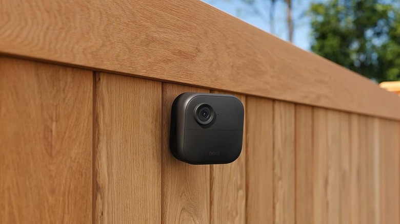 Black Blink camera on wood fence