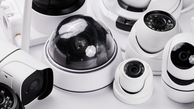 assorted home security cameras on white table