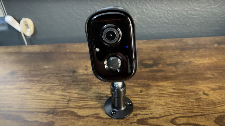 Black tabletop camera on wood desk