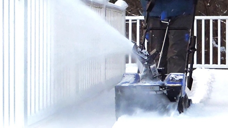 Person blowing snow with a Snow Joe battery-powered machine