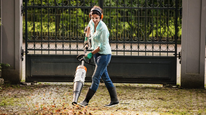 Woman using the STIHL KombiSystem blower attachment